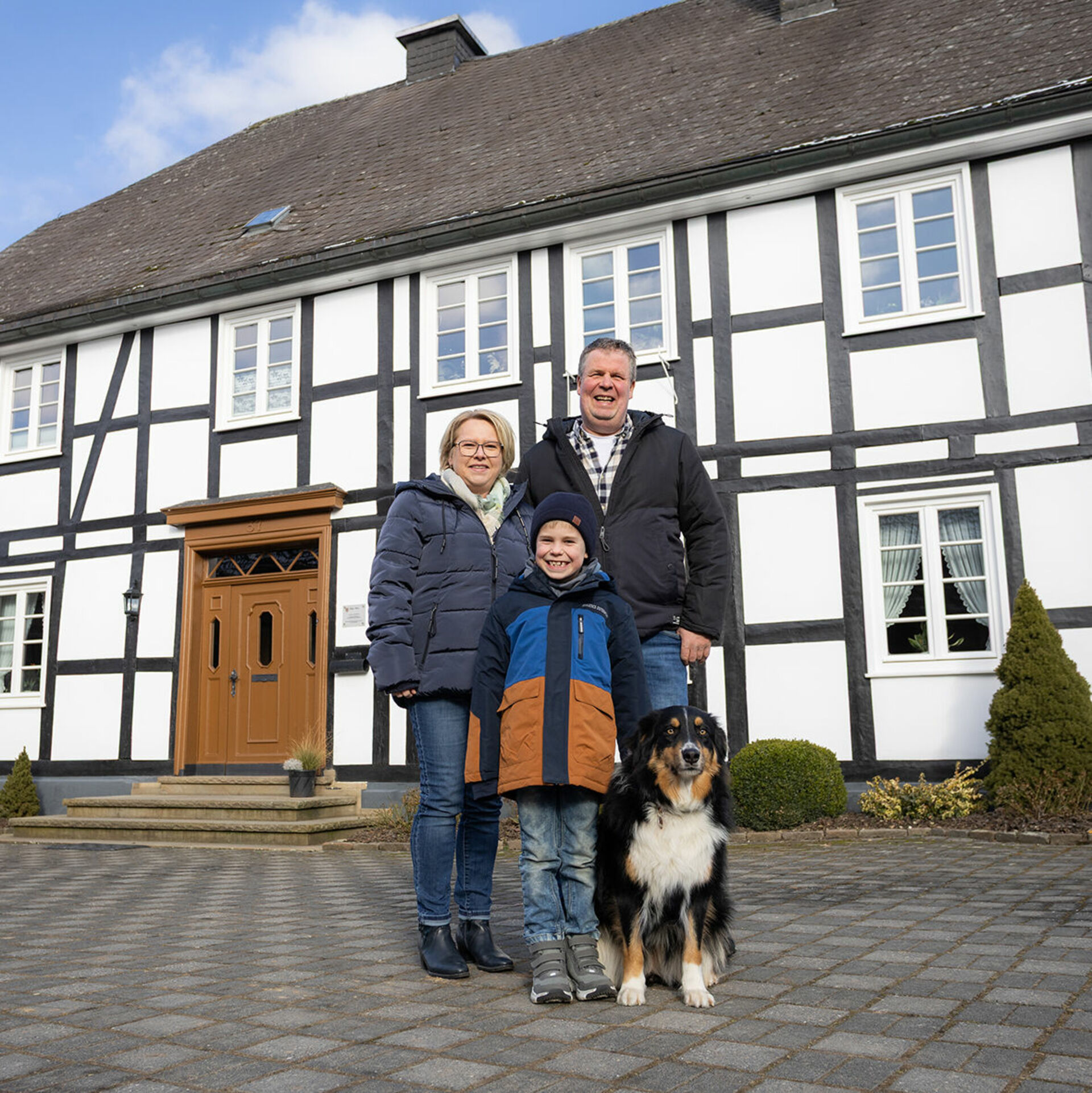 Familie mit Hund vor Fachwerkhaus 