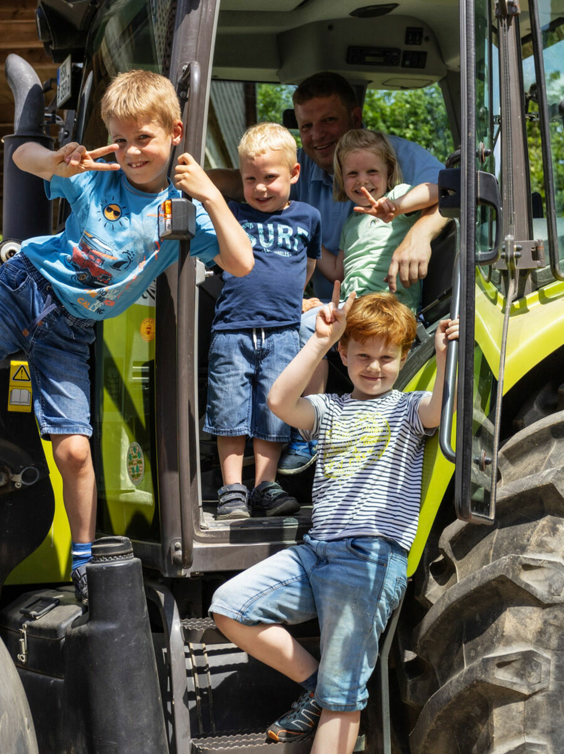 Kinder mit Mann auf Trecker 