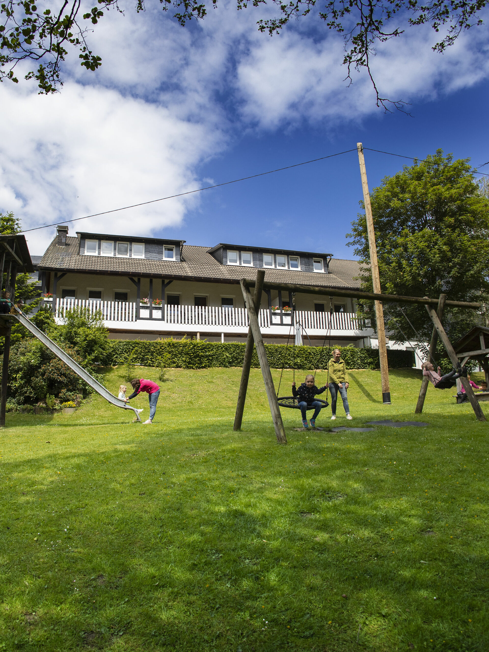 Blick auf Hof, im Vordergrund eine Wiese mit Spielplatz