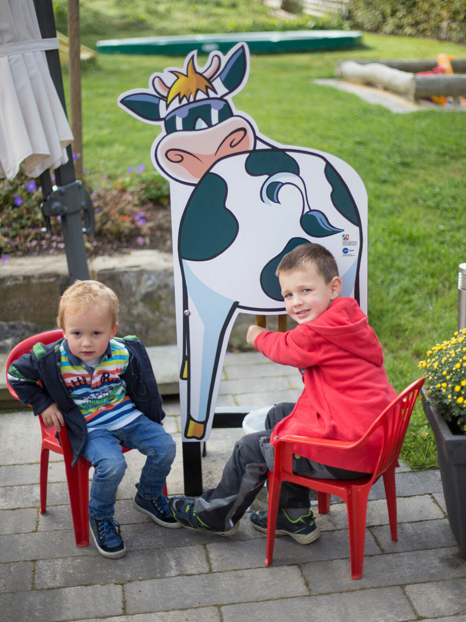 Kinder üben das Kühemelken an einem Kuh-Modell auf dem Gut Frielinghausen im Schmallenberger Kinderland.